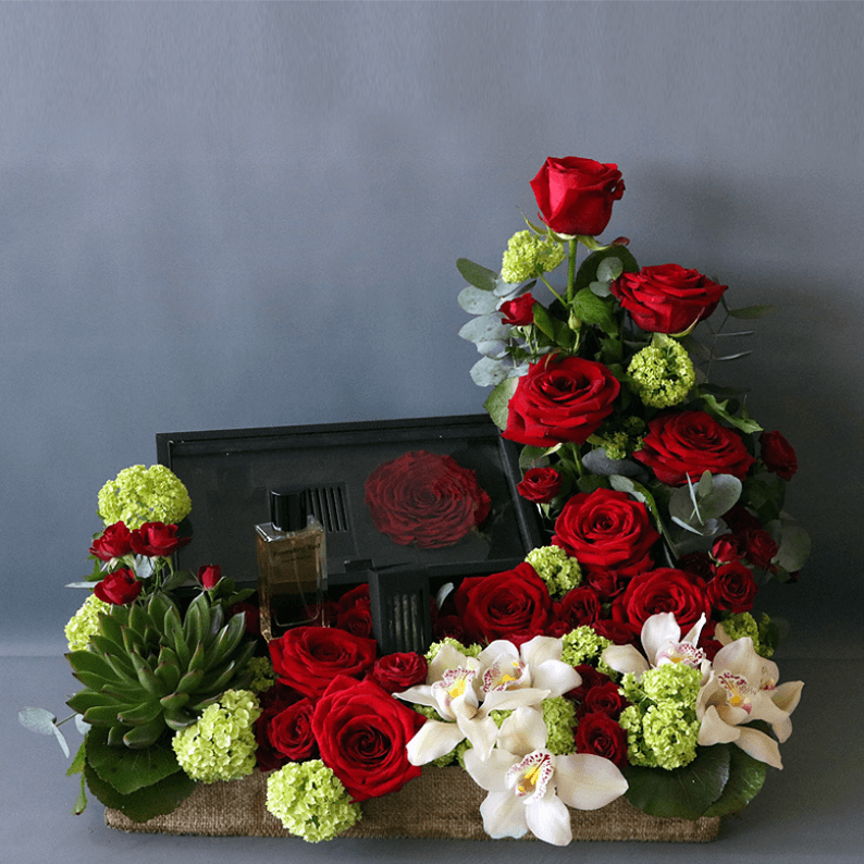 Revealing Red True Love box of revealing red perfume with red roses, cymbidium orchids and succulents